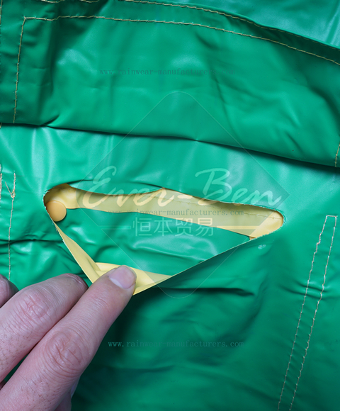 Yellow plastic hooded rain mac pockets